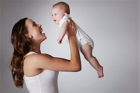 studio shot - Mother lifting baby daughter Stock Photo - Premium Royalty-Free, Code: 614-06897883