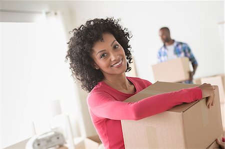 Mid adult woman carrying cardboard boxes Foto de stock - Royalty Free Premium, Número: 614-06897956