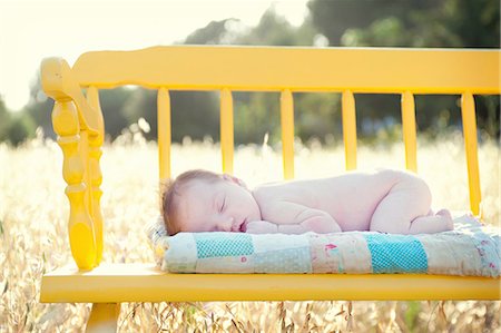 desnudo - Newborn baby girl sleeping on yellow bench in field Foto de stock - Sin royalties Premium, Código: 614-06898013