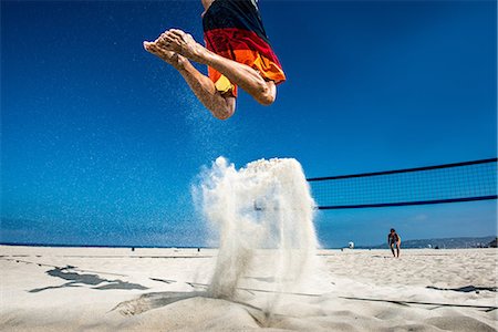 swimsuit for 40 year old woman - Male beach volleyball player jumping mid air Stock Photo - Premium Royalty-Free, Code: 614-06898036