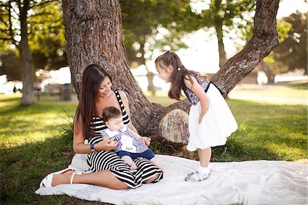 Mother and two daughters on picnic blanket Foto de stock - Sin royalties Premium, Código: 614-06898053