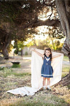 people under tree - Portrait of girl holding sheet with arms out under tree Stock Photo - Premium Royalty-Free, Code: 614-06898067