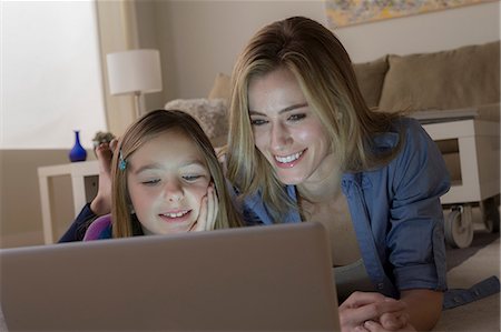 face woman lighting - Mother and daughter looking at laptop Stock Photo - Premium Royalty-Free, Code: 614-06898284