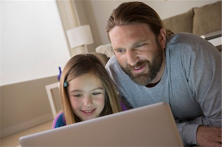 family technology home - Father and daughter looking at laptop Stock Photo - Premium Royalty-Free, Code: 614-06898283