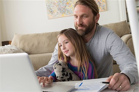 family sitting in couch - Father with child using laptop Stock Photo - Premium Royalty-Free, Code: 614-06898292