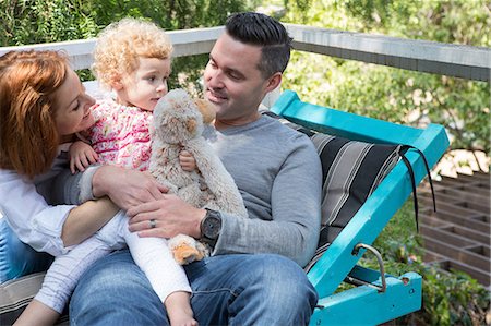 father and daughter embrace - Couple on deckchair with child Stock Photo - Premium Royalty-Free, Code: 614-06898409