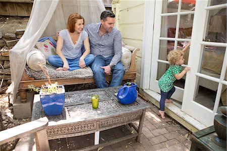 female child jeans sitting - Husband & wife looking at child Stock Photo - Premium Royalty-Free, Code: 614-06898414