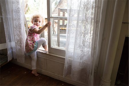 Child climbing over opened window Foto de stock - Sin royalties Premium, Código: 614-06898420