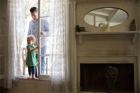 fireplace - Father and child entering room from verandah Stock Photo - Premium Royalty-Free, Code: 614-06898432