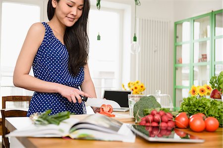 red home people - Woman slicing tomatoes Stock Photo - Premium Royalty-Free, Code: 614-06898502