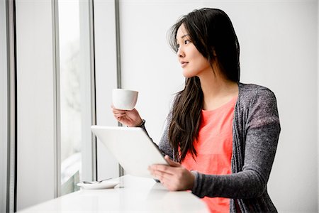 female coffee tablet window - Woman with digital tablet during break looking out window Stock Photo - Premium Royalty-Free, Code: 614-06898517