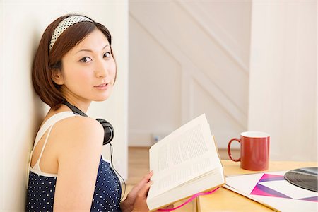 Woman looking up from book Foto de stock - Sin royalties Premium, Código: 614-06898529