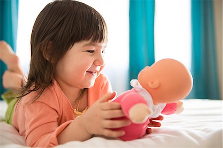poupées - Girl playing with dolly in bedroom Photographie de stock - Premium Libres de Droits, Code: 614-06974044