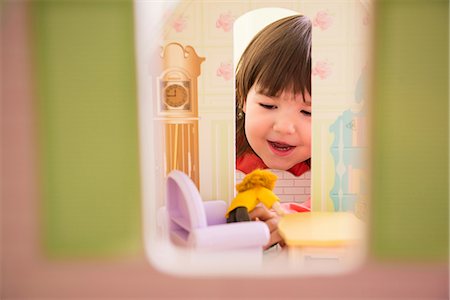 Girl playing with doll house Foto de stock - Royalty Free Premium, Número: 614-06974052