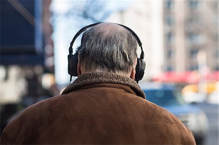 Rear view of senior man wearing headphones Stock Photo - Premium Royalty-Free, Code: 614-06974292