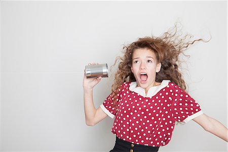 Girl with tin can telephone, mouth open Stock Photo - Premium Royalty-Free, Code: 614-06974357
