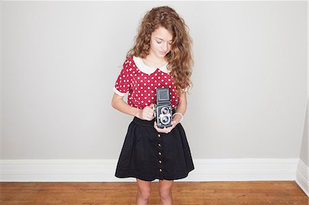 retro teenagers - Girl holding old camera Stock Photo - Premium Royalty-Free, Code: 614-06974365