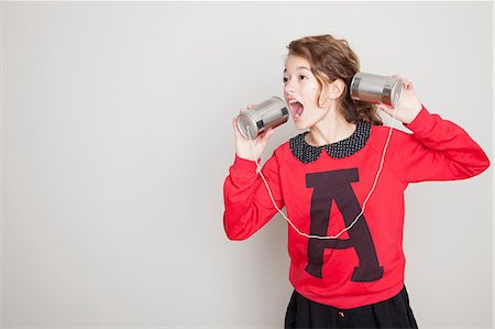 Girl shouting into tin can telephone Foto de stock - Royalty Free Premium, Número: 614-06974367
