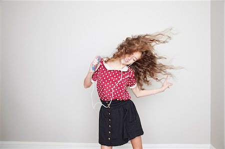 dancing on white background - Girl wearing headphones, dancing and holding mp3 player Foto de stock - Sin royalties Premium, Código: 614-06974363