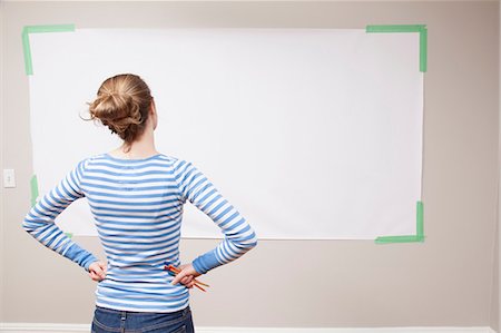 Girl looking at blank space on wall Stock Photo - Premium Royalty-Free, Code: 614-06974380