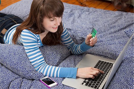 simsearch:614-06974313,k - Girl lying on bed with laptop internet shopping Foto de stock - Sin royalties Premium, Código: 614-06974392