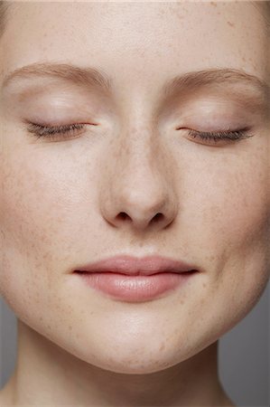 Close up of young woman's face with eyes closed Photographie de stock - Premium Libres de Droits, Code: 614-06974548