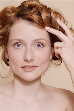 portrait woman calm - Young woman with curly red hair biting lip Stock Photo - Premium Royalty-Free, Code: 614-06974567