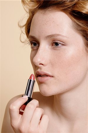 Young woman applying lipstick, close up Stock Photo - Premium Royalty-Free, Code: 614-06974562