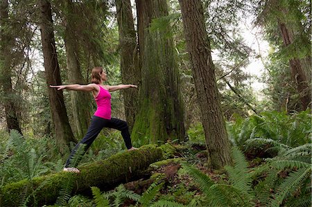 Mature woman performing warrior pose in forest Stock Photo - Premium Royalty-Free, Code: 614-06974598