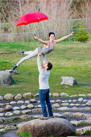 Mid adult dancers performing with red umbrellas in stone circle Stock Photo - Premium Royalty-Free, Code: 614-06974613
