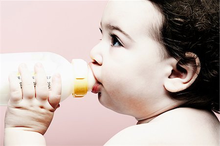 Portrait of baby girl drinking milk from bottle Stock Photo - Premium Royalty-Free, Code: 614-06974697