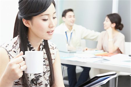 simsearch:614-07031401,k - Woman holding mug, colleagues in background Stock Photo - Premium Royalty-Free, Code: 614-06974781