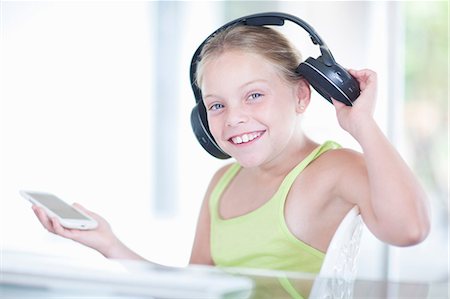 preteen girl and tank top - Girl listening to music on a smartphone Stock Photo - Premium Royalty-Free, Code: 614-06973534