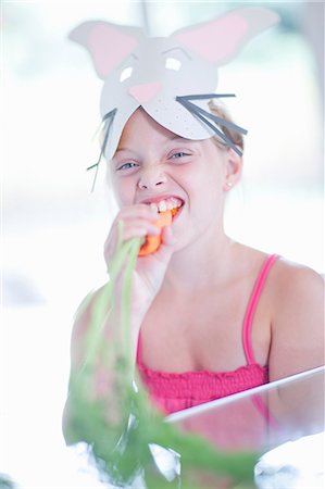 Girl in rabbit costume eating carrot Foto de stock - Sin royalties Premium, Código: 614-06973552