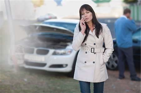 Woman on mobile phone after car accident Stock Photo - Premium Royalty-Free, Code: 614-06973605