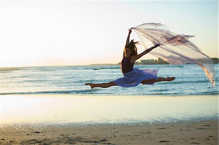 dancer jumping in the air - Young woman dancing on sunlit beach Stock Photo - Premium Royalty-Free, Code: 614-06973607