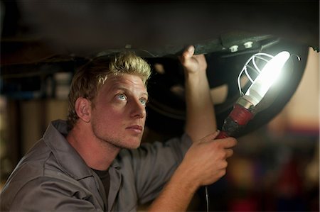 Car mechanic at work in service bay Stock Photo - Premium Royalty-Free, Code: 614-06973681