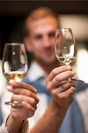 Holding up wine glass to check colour of wine Photographie de stock - Premium Libres de Droits, Code: 614-06973698