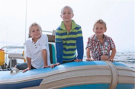 simsearch:640-02951657,k - Portrait of three young boys at sea in dinghy Fotografie stock - Premium Royalty-Free, Codice: 614-06973745