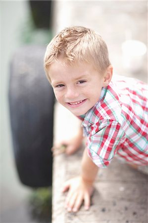 Portrait of young boy leaning on pier wall Foto de stock - Sin royalties Premium, Código: 614-06973749