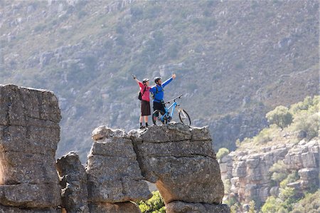 Mountain biking couple celebrating on rock formation Foto de stock - Sin royalties Premium, Código: 614-06973764