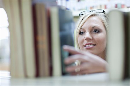 Female student choosing book in library Stock Photo - Premium Royalty-Free, Code: 614-06973818