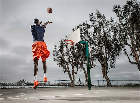 successful african american - Young basketball player jumping to score Stock Photo - Premium Royalty-Free, Code: 614-06973897