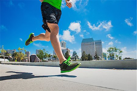 Young man jogging in city, low section Stock Photo - Premium Royalty-Free, Code: 614-06973917