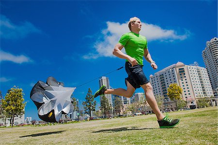 skydiving - Young man jogging in city park with parachute Stock Photo - Premium Royalty-Free, Code: 614-06973920