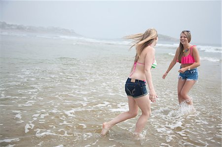 Young women playing in tide on beach Photographie de stock - Premium Libres de Droits, Code: 614-07031115