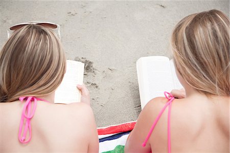 Young women reading books on beach Stock Photo - Premium Royalty-Free, Code: 614-07031121