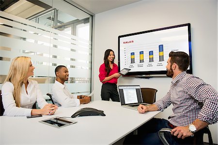 Young business colleagues looking at digital table in meeting in conference room Stock Photo - Premium Royalty-Free, Code: 614-07031142