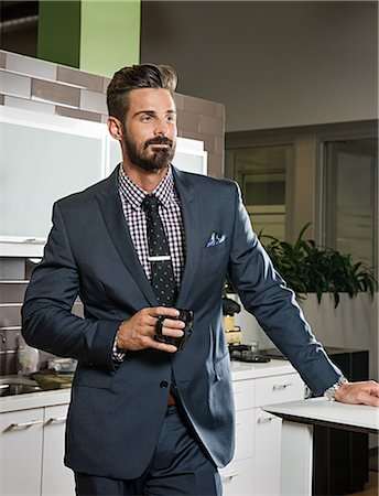 Young businessman holding cup in office kitchen Fotografie stock - Premium Royalty-Free, Codice: 614-07031159