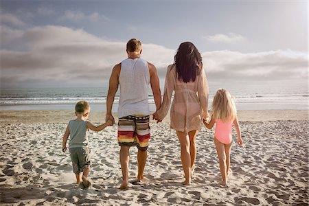 Young family holding hands together on beach, rear view Photographie de stock - Premium Libres de Droits, Code: 614-07031180